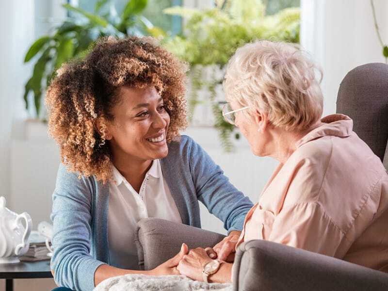 caregiver and resident holding hands